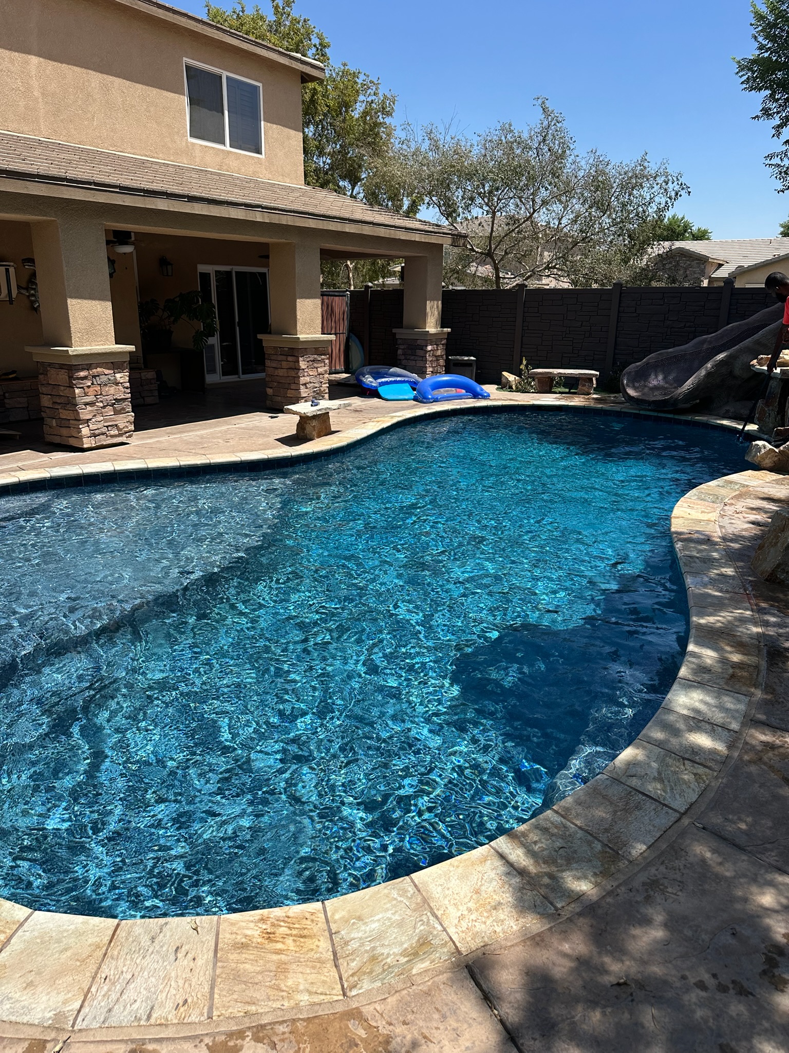 Curved residential pool with waterslide