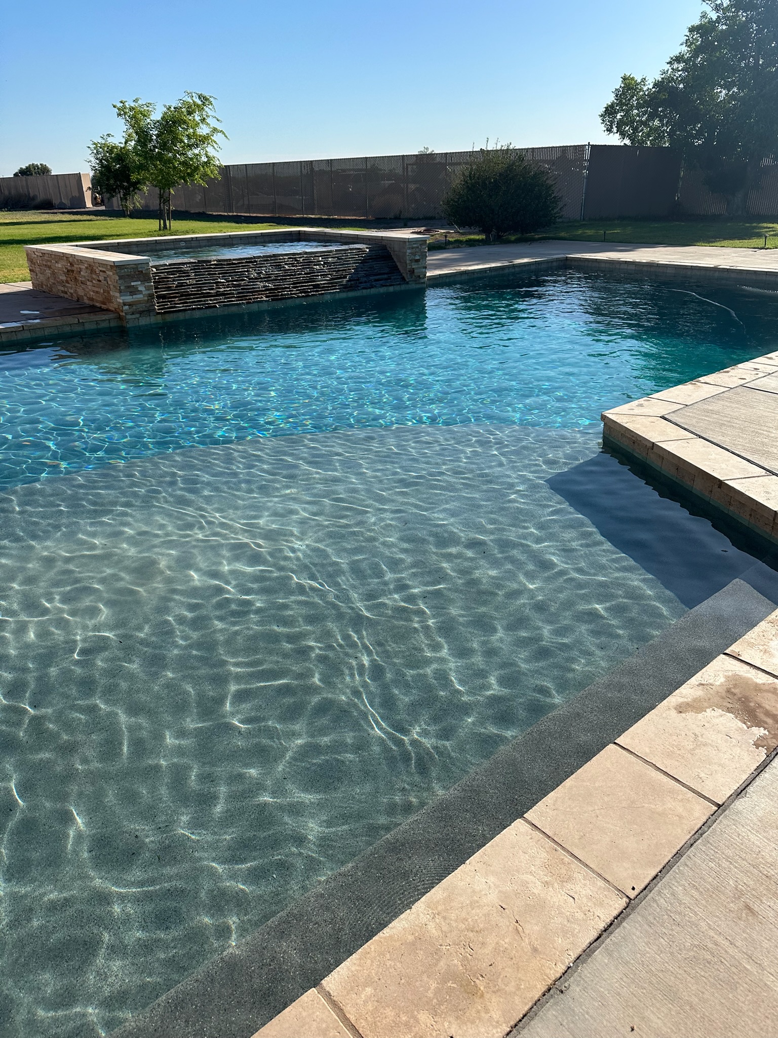 Clear residential pool with raised spa