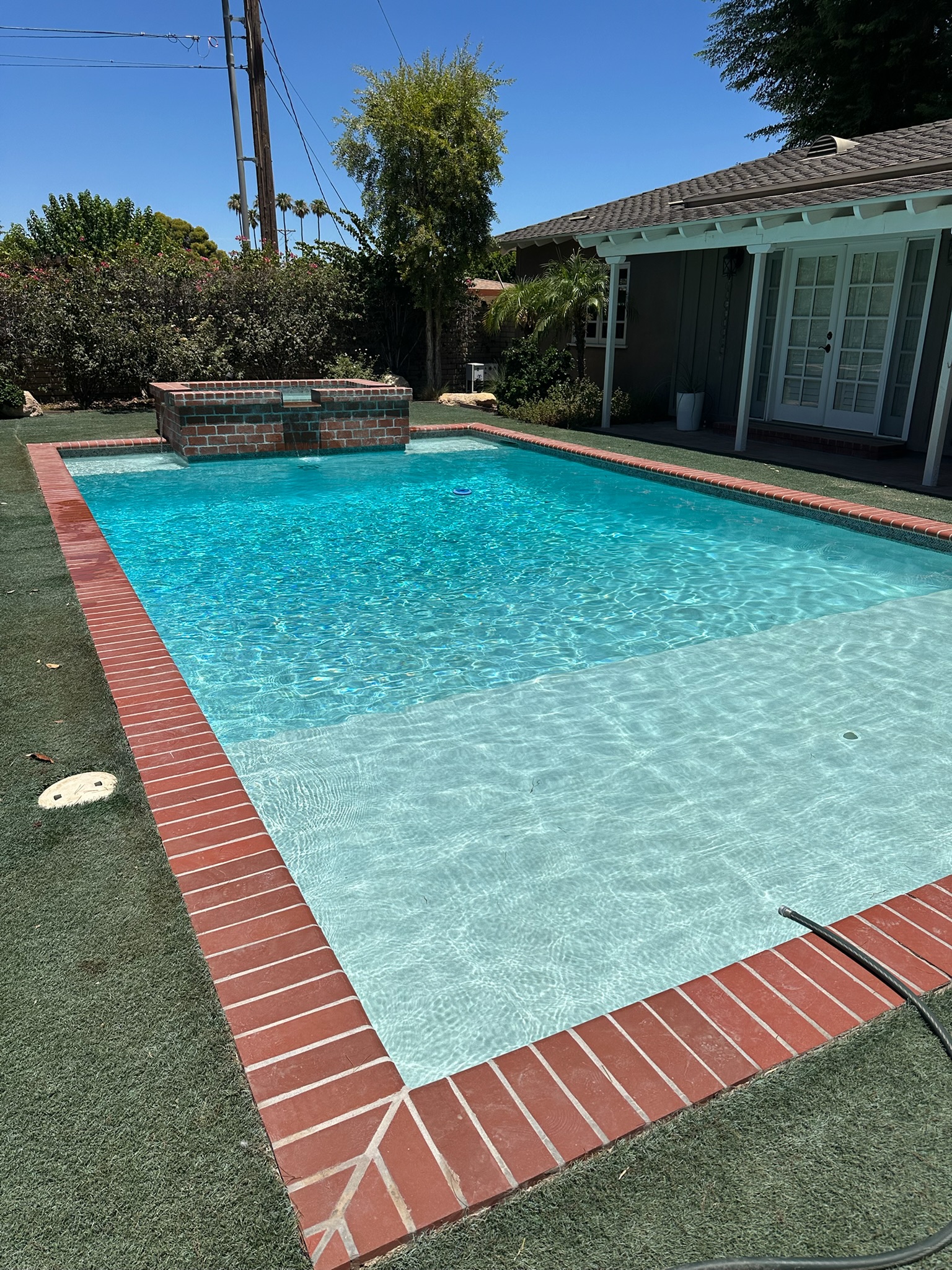 Clean backyard pool with brick spa